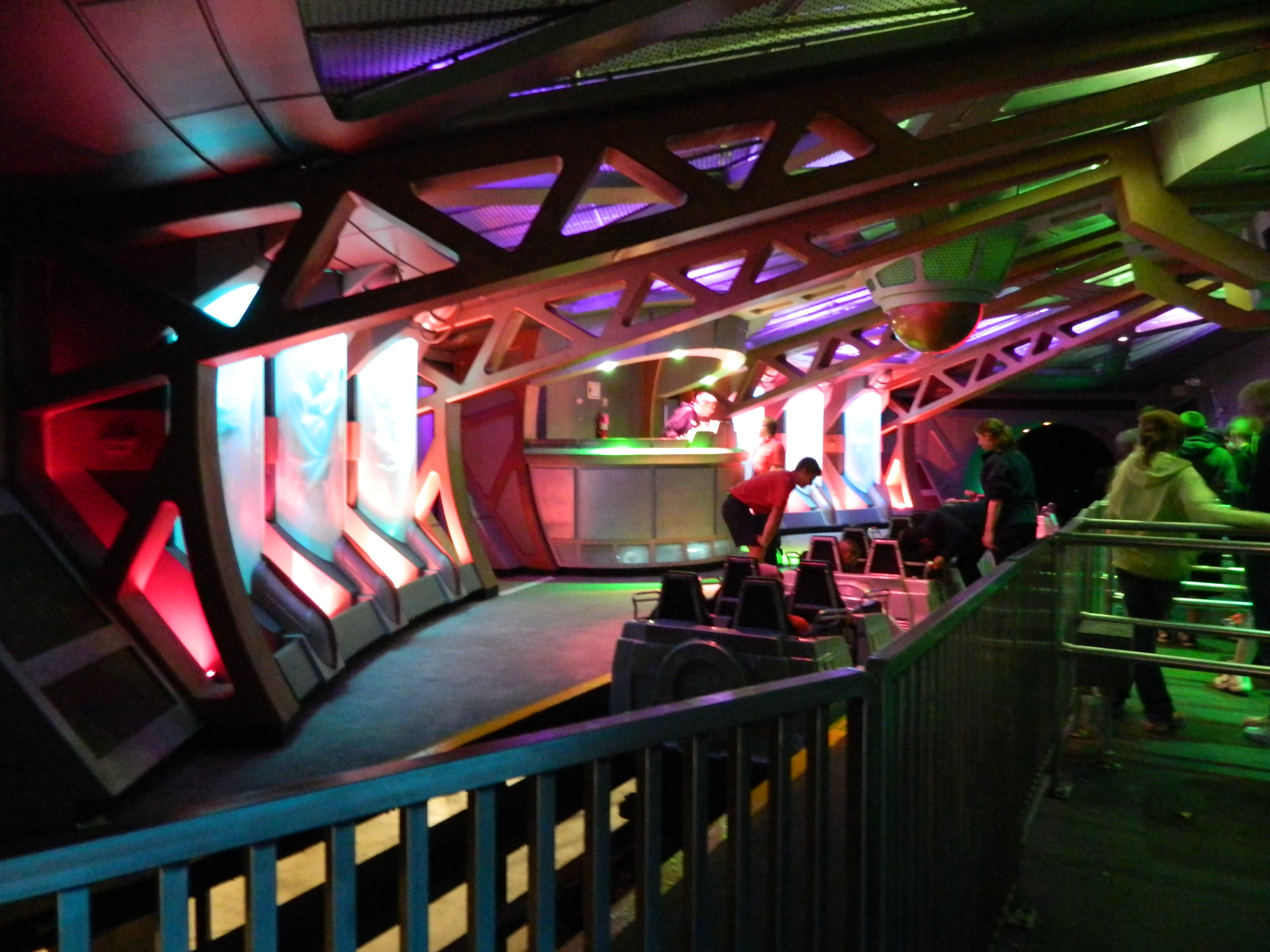 Room containing people and roller coaster train cars